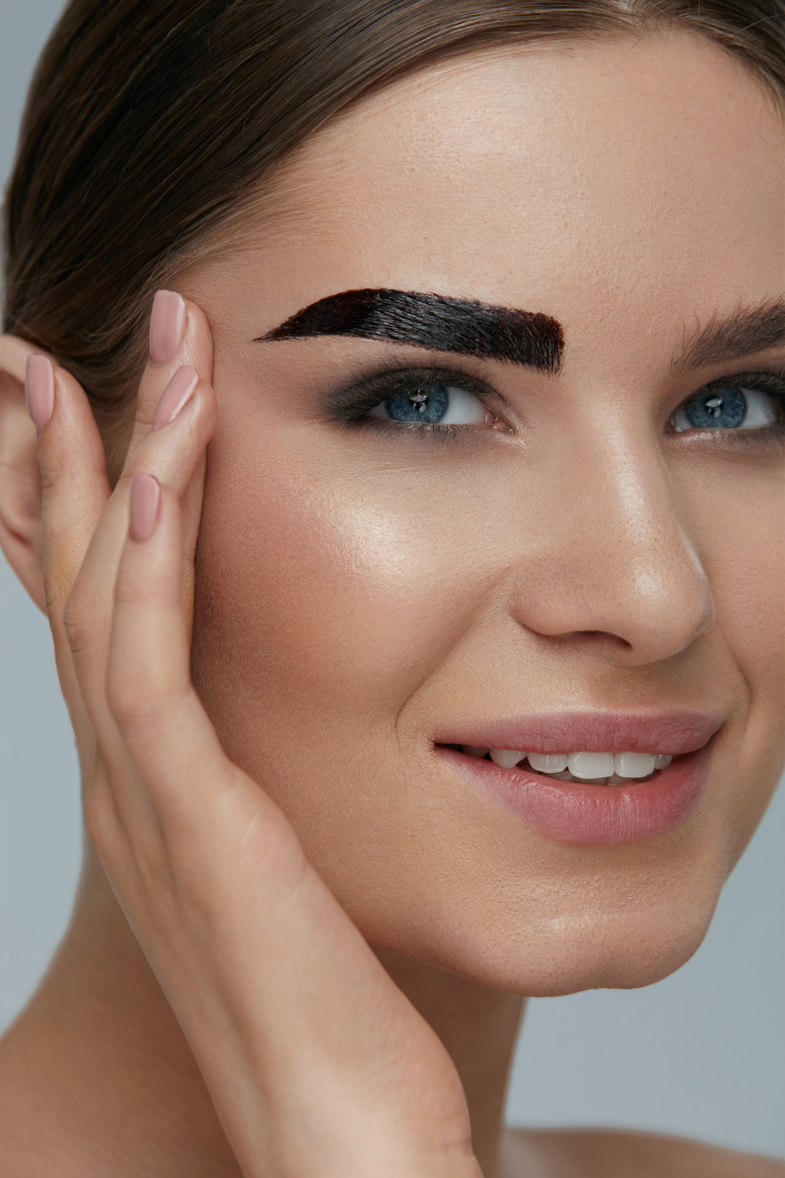 Beauty makeup. Woman coloring eyebrow with brow gel tint